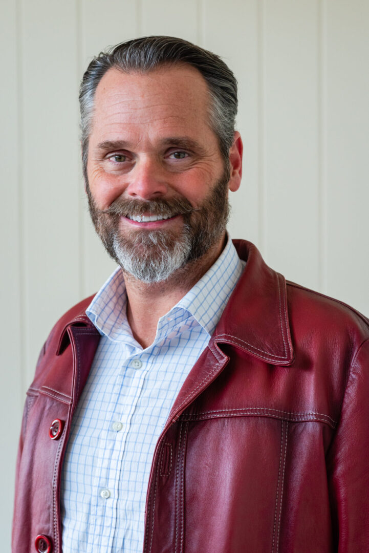 A man with a beard and red jacket